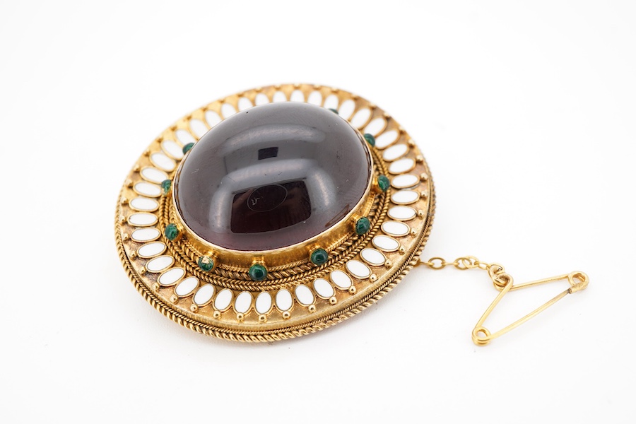 A garnet brooch, second half 19th century, designed in the Archaeological Revival style, centring on a large foiled cabochon garnet measuring approximately 25 x 21mm, within a border applied with rope twist decoration an